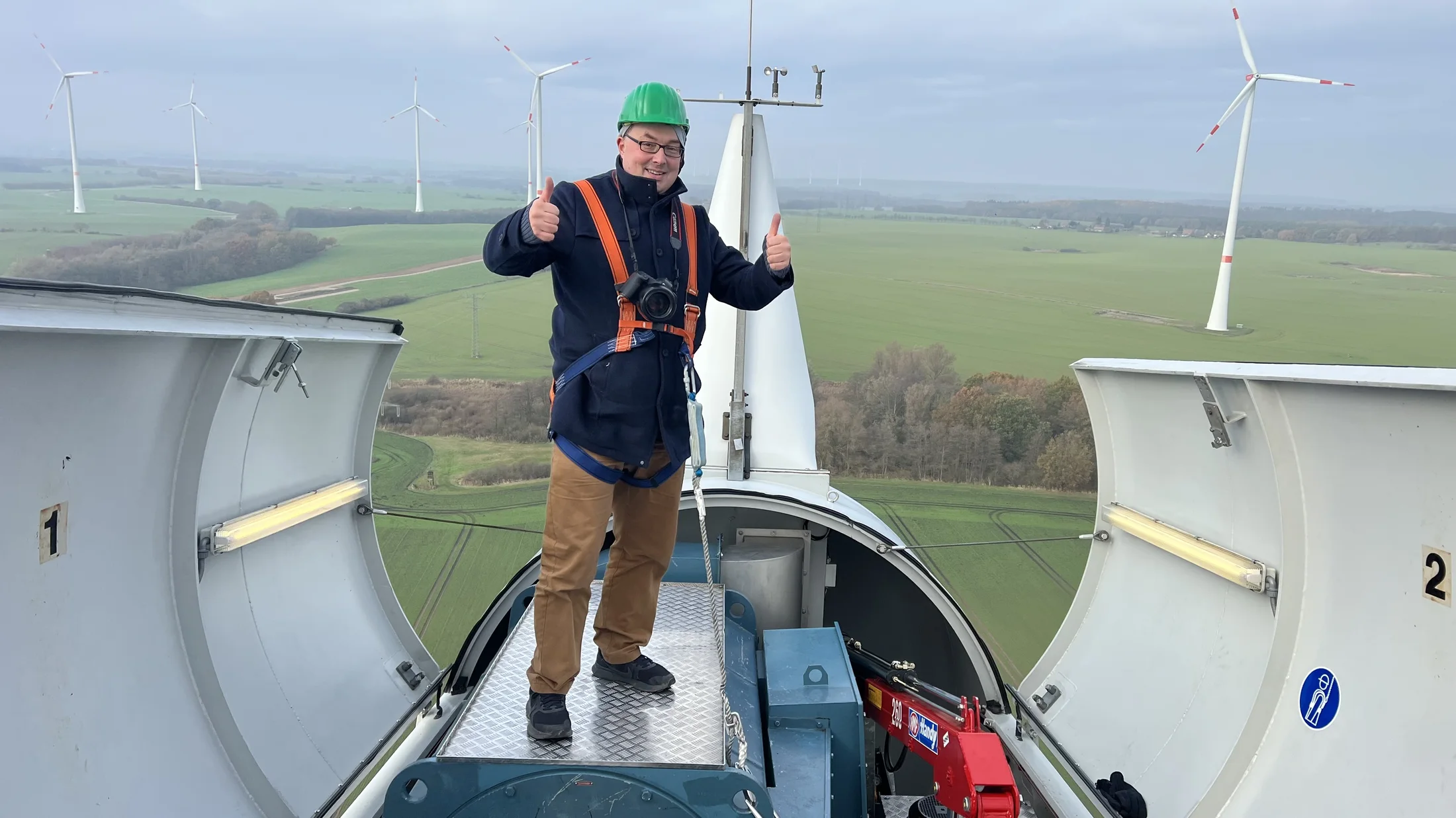 Claas Abraham mit Kamera und Sicherung auf einer Windanlage.