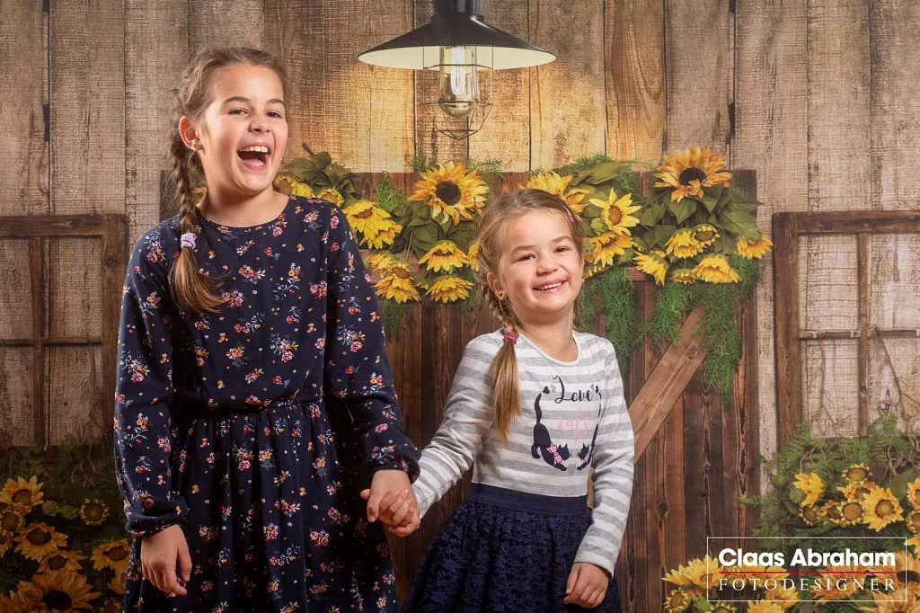 Zwei lachende Kinder beim Fotoshooting im Studio.
