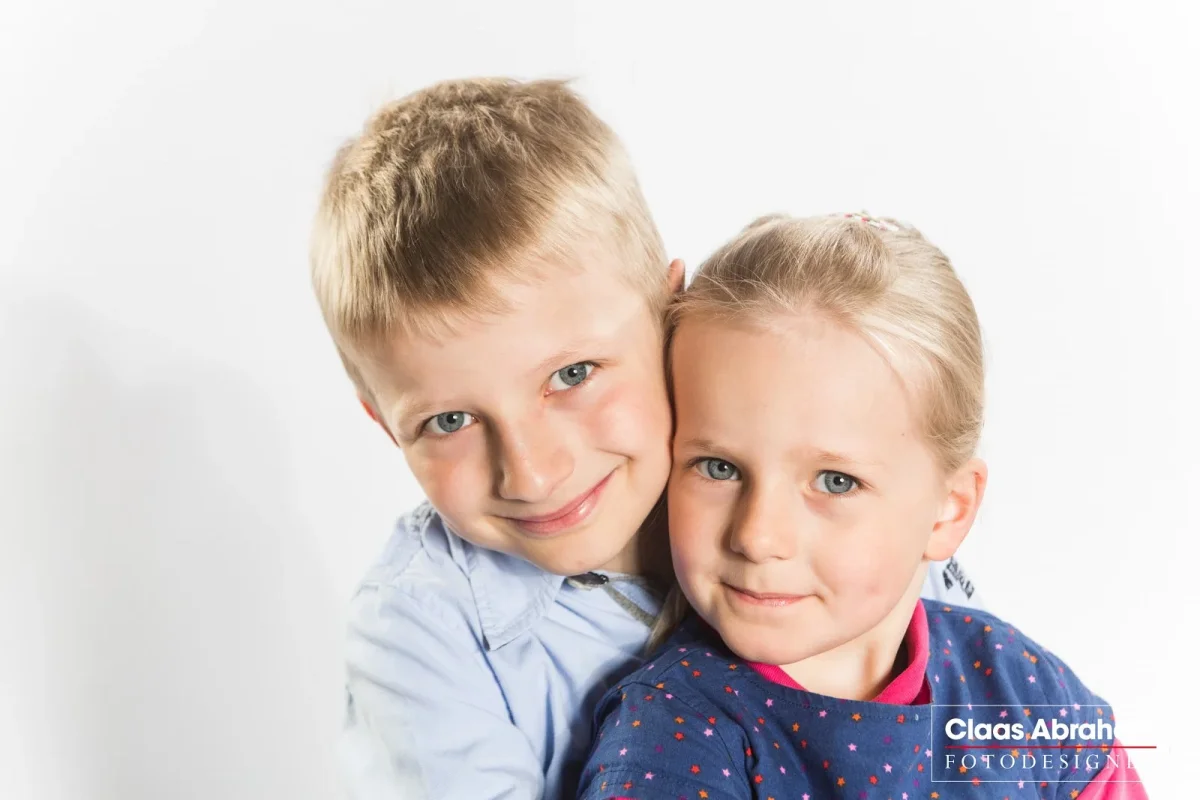 Ein Junge und ein Mädchen stehen für ein gemeinsames Geschwisterfoto eng beieinander.