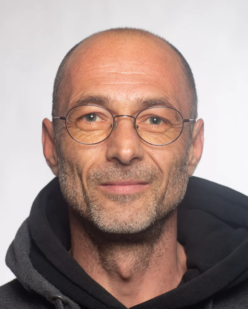 Beispiel eines Passbilds mit hellem Hintergrund und Brille.